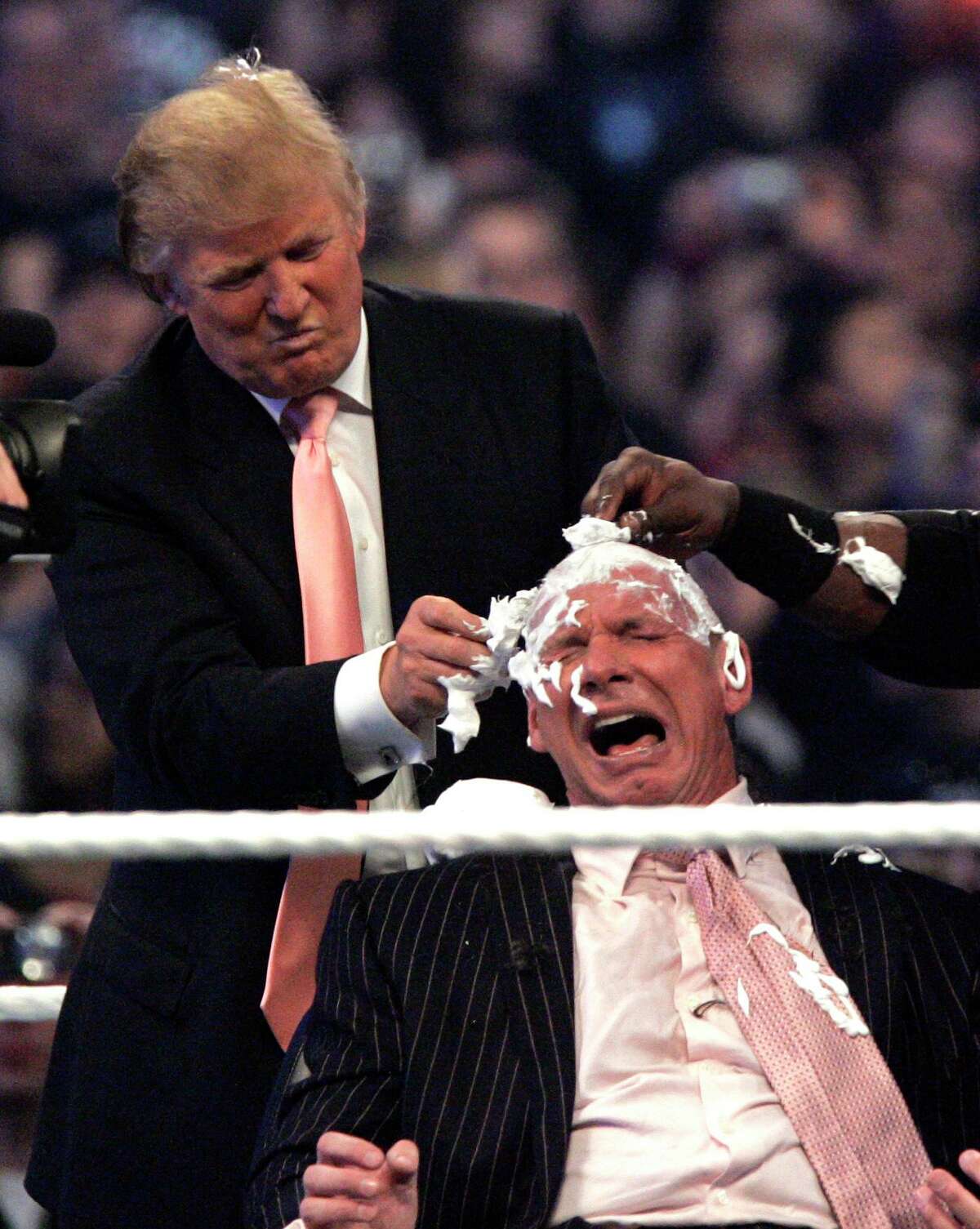 Donald Trump shaves the head of Vince McMahon after Trump's representative wrestler Bobby Lashley defeated Umaga at Wrestlemania 23 at Ford Field in Detroit, Sunday, April 1, 2007. (AP Photo/Carlos Osorio)