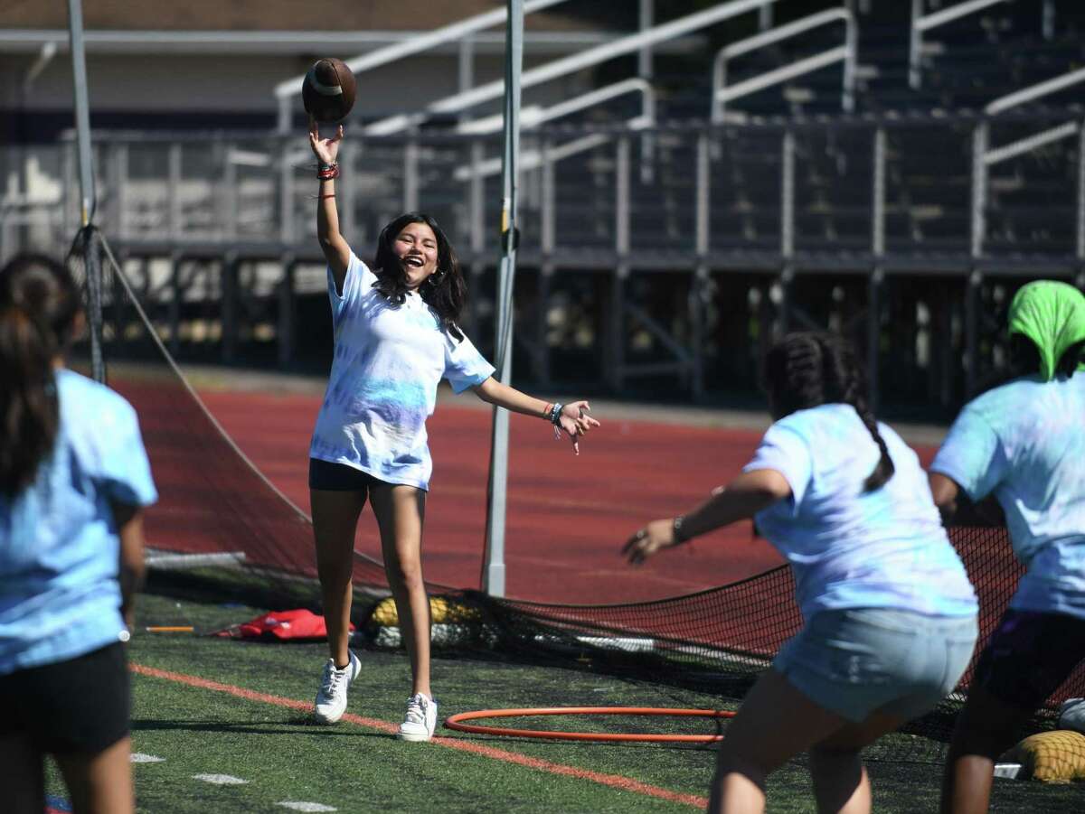 Rising freshman Emily Rescalvo throws a football to her friends during the RISE Network Summer Bridge program at Westhill High School in Stamford, Conn. Thursday, Aug. 18, 2022. The Summer Bridge program is held at nine schools in the RISE Network across the state to give incoming high school freshmen an opportunity to make friends, meet teachers, and familiarize themselves with their new environment before the school year starts.