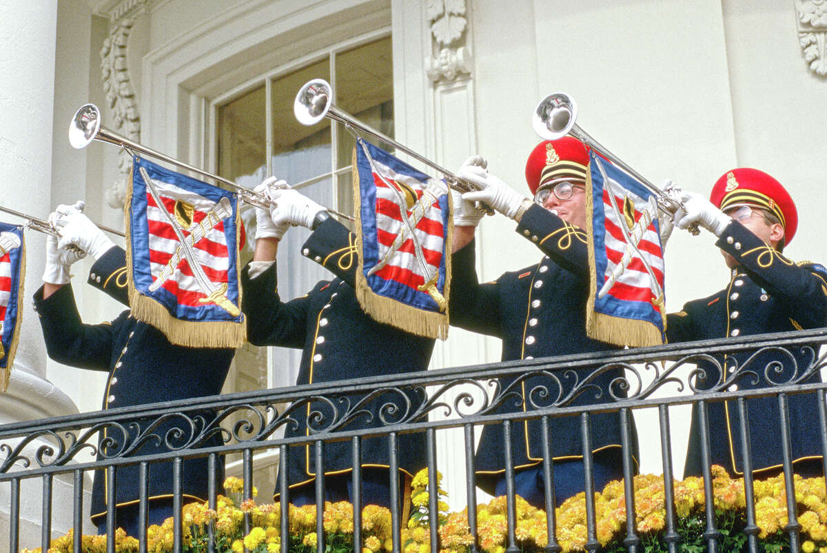 Members of the Army Herald Trumpets perform at a state ceremony from the balcony of the White House.