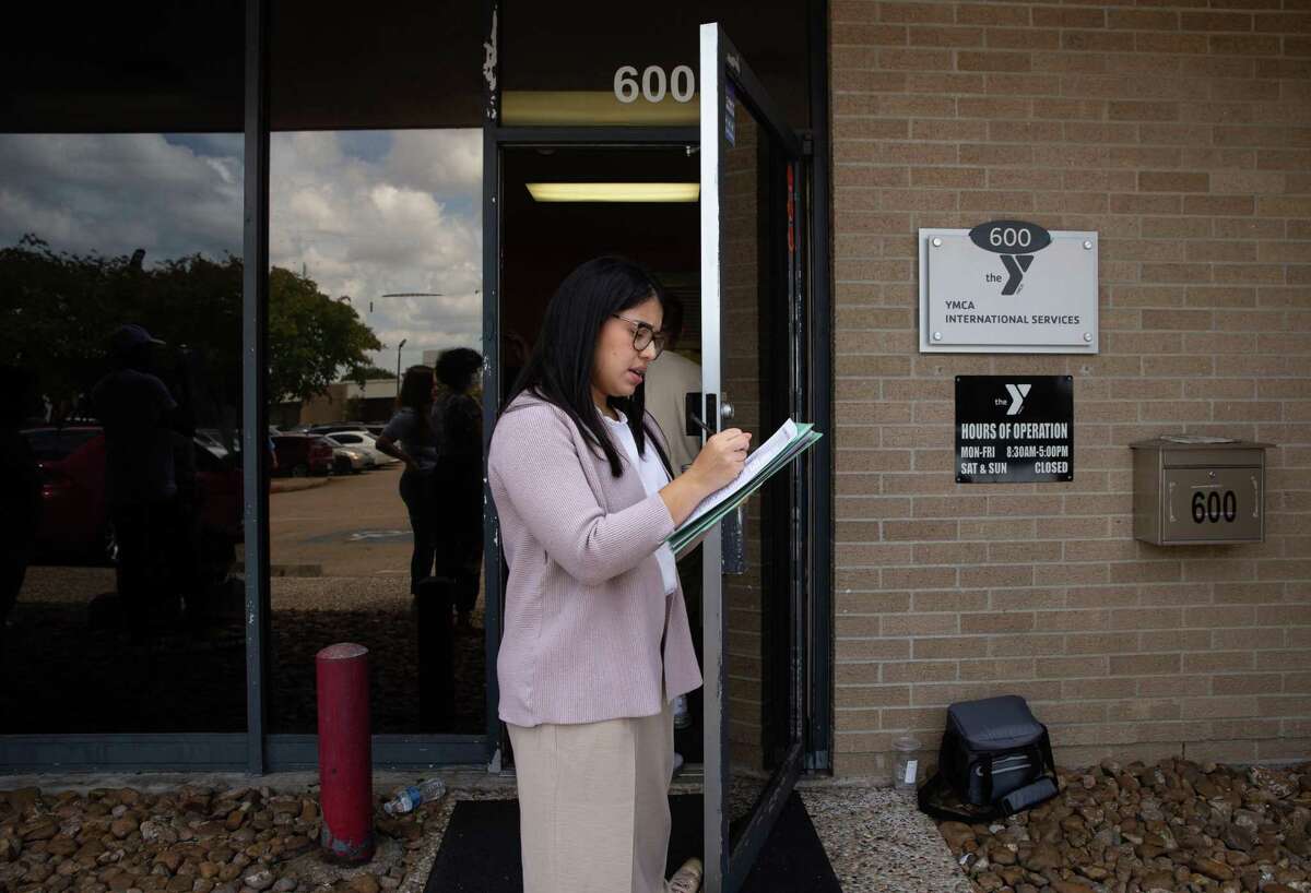 YMCA International Services Program Specialist Oriana Davila checks refugees, most are recently arriving Cubans, in for orientation Monday, Aug. 15, 2022, in Houston.
