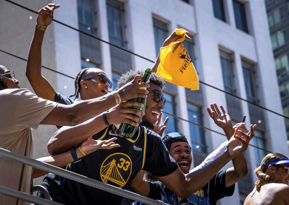 James Wiseman holds a bottle of champagne he was spraying the crowd with as the Golden State Warriors celebrated their 2022 NBA Champsionship with a parade down Market Street in San Francisco, Calif., on Monday, June 20, 2022.