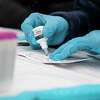 抽血者Khaliun应准备BinaxNow COVID-19测试卡在社区测试网站由森en Salud任务地区的旧金山,加利福尼亚,2022年1月7日。