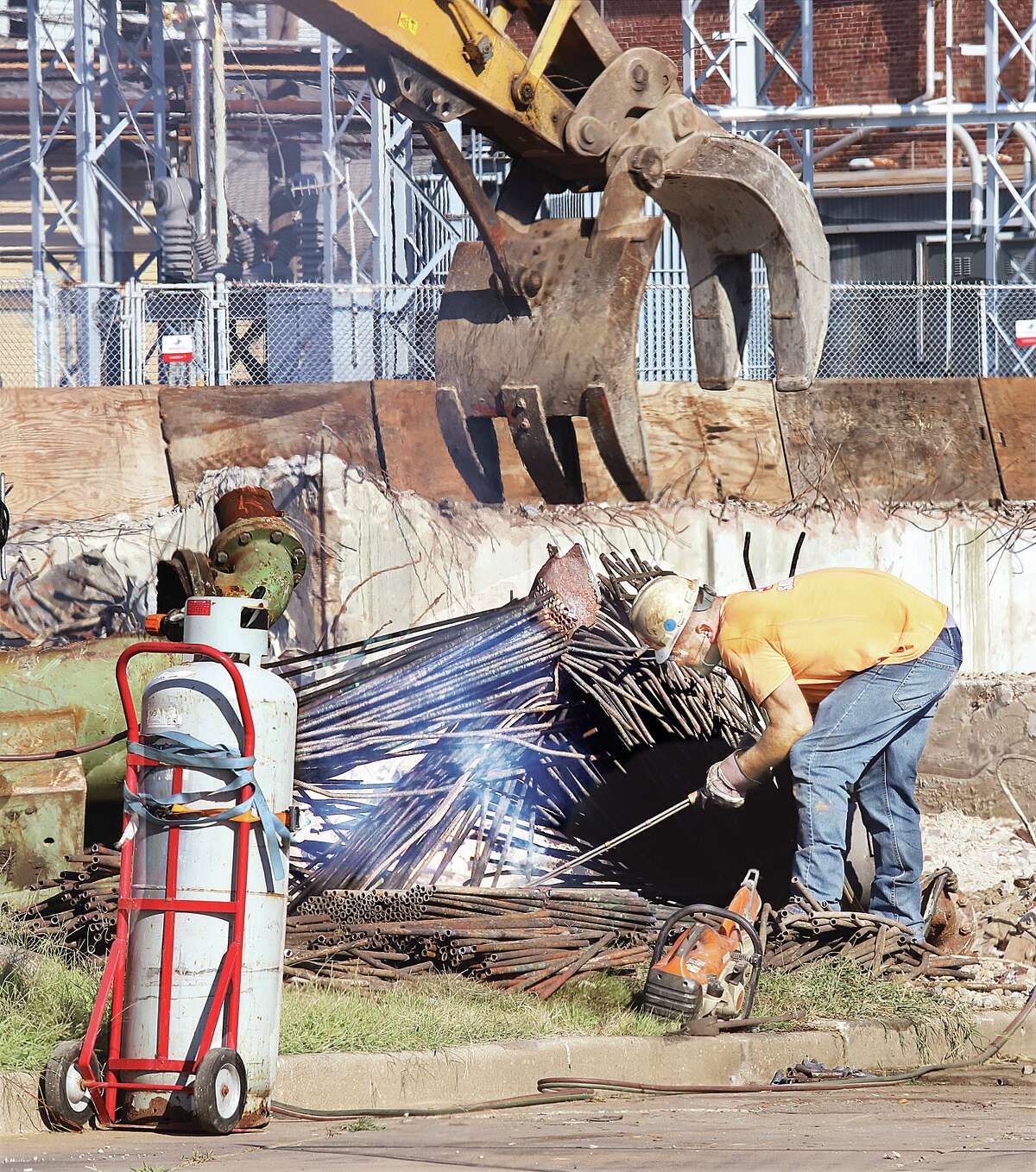 A worker cuts up reinforcing bar stock at the demolition site of the former Olin Headquarters Building on Shamrock Street in East Alton Thursday. Spirtas Wrecking Co. from St. Louis has been working for over a month to tear down the office building which is owned by Wieland Co.
