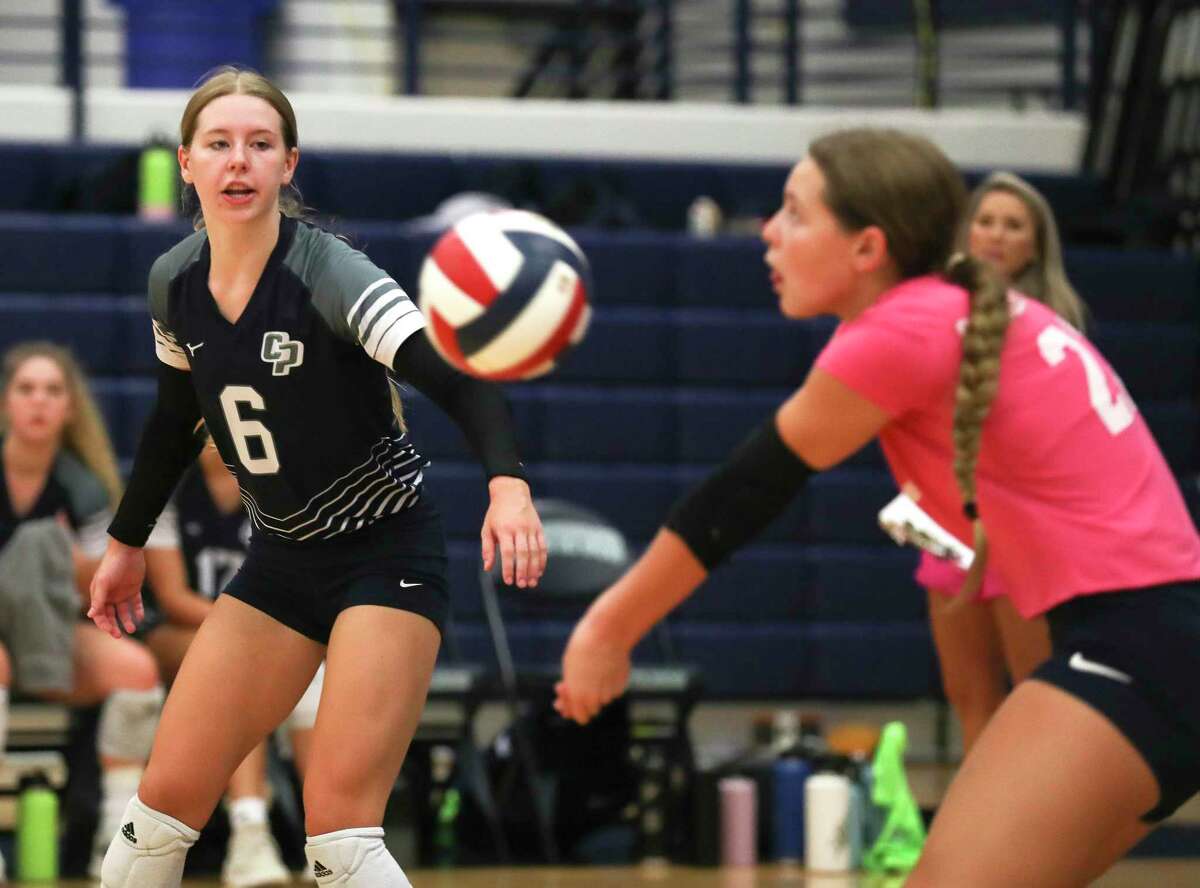 College Park's Mallory Madison (6) looks on as Morgan Madison (22) returns a serve in the first set of a non-district high school volleyball match at Kingwood High School, Thursday, Aug. 18, 2022, in Kingwood.