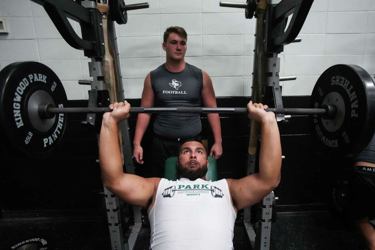 Kingwood Park center Trent Savage (top) spots fellow offensive lineman Erick Zapata as he lifts in the weight room. The seniors have helped the Panthers return to the playoffs for the first time since 2019.