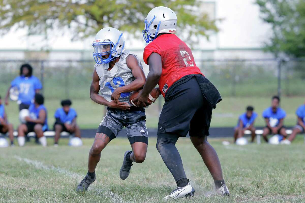 Westbury High School running back Michael Everson, left, takes a handoff from quarterback Rickey Golighty, right, during football practice at the campus practice field Wednesday, Aug. 17, 2022 in Houston, TX.