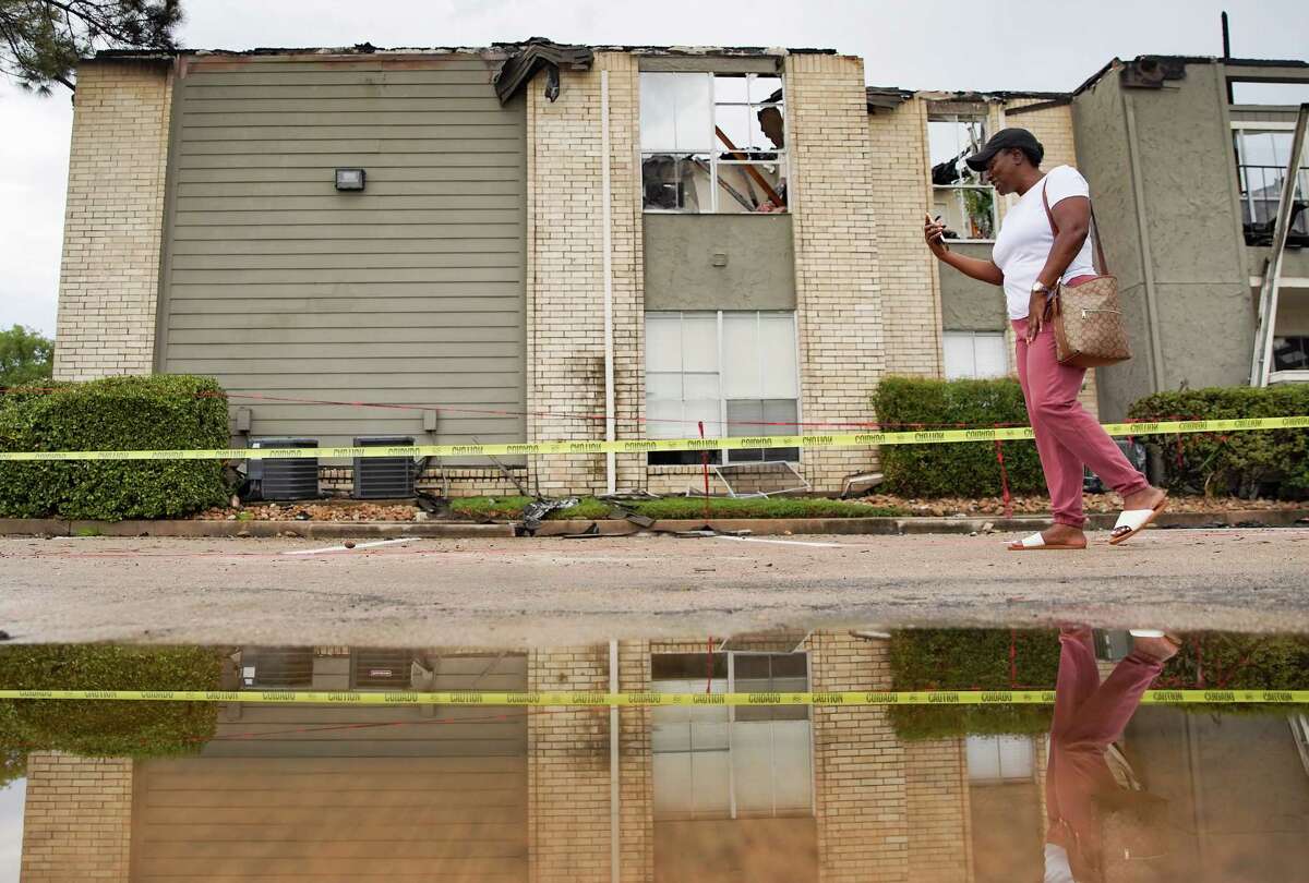 Sonia Joseph talks on the phone as she walks by her damaged apartment building at The Landing at Clear Lake Apartments on Friday, Aug. 19, 2022 in Webster. Joseph was leaving work early because of flooding, when she got a call from her husband that their home was on fire due to a lightning strike. Her husband, Egbert and three boys got out safely.