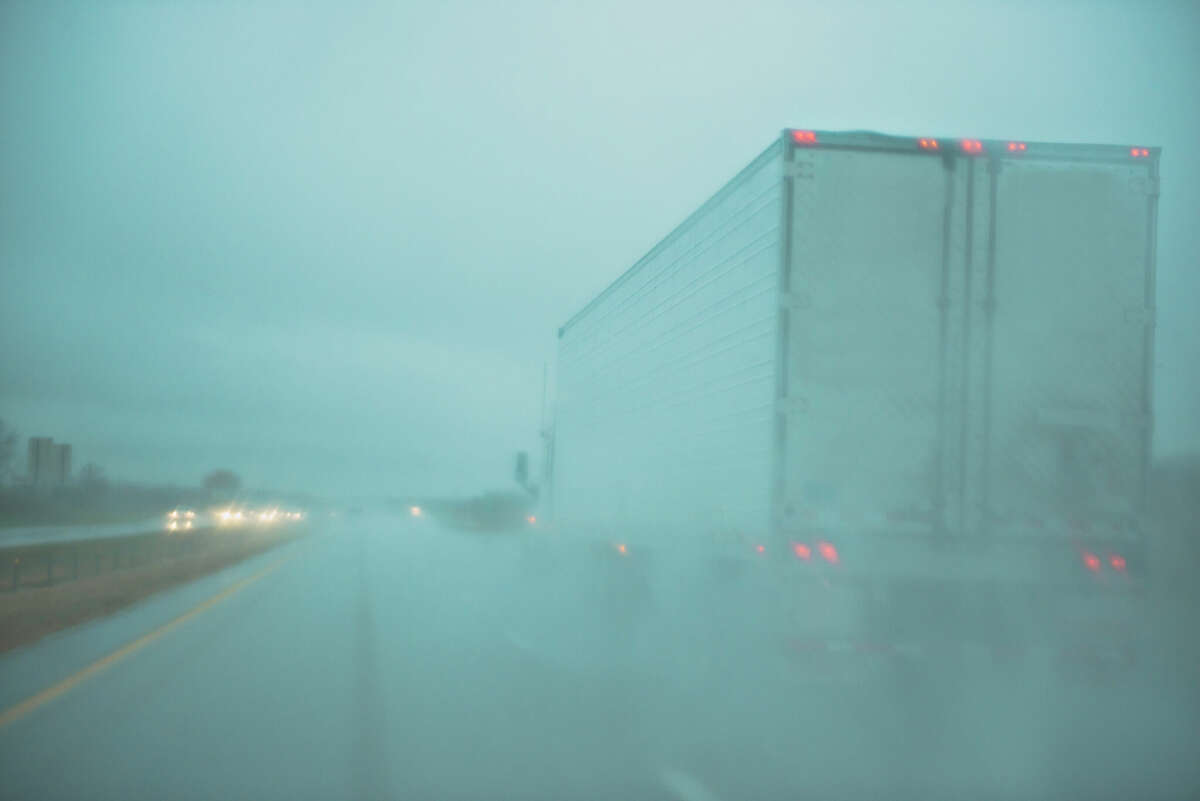 Stock photo of traffic in a bad rain storm. On Thursday strong winds blew a semitruck off a Houston-area overpass, its driver narrowly escaping before the vehicle crashed onto the roadway below.