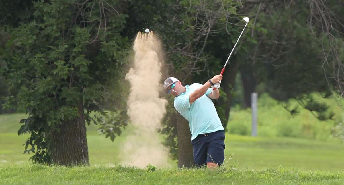 A golfer kicks up a little dust as he blasts out of a sand trap during a recent round at The Links Golf Course.