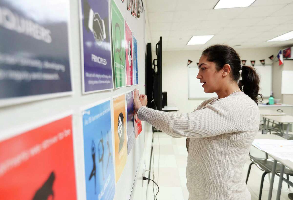 Spanish teacher Rosa Fernandez positions new signs in her classroom at Chavez High School, Thursday, Aug. 11, 2022, in Houston. The Houston Independent School District, the state’s largest system, starts school on Aug. 22, despite a shortage of educators that have left districts across the Houston region scrambling to fill thousands of teacher vacancies.