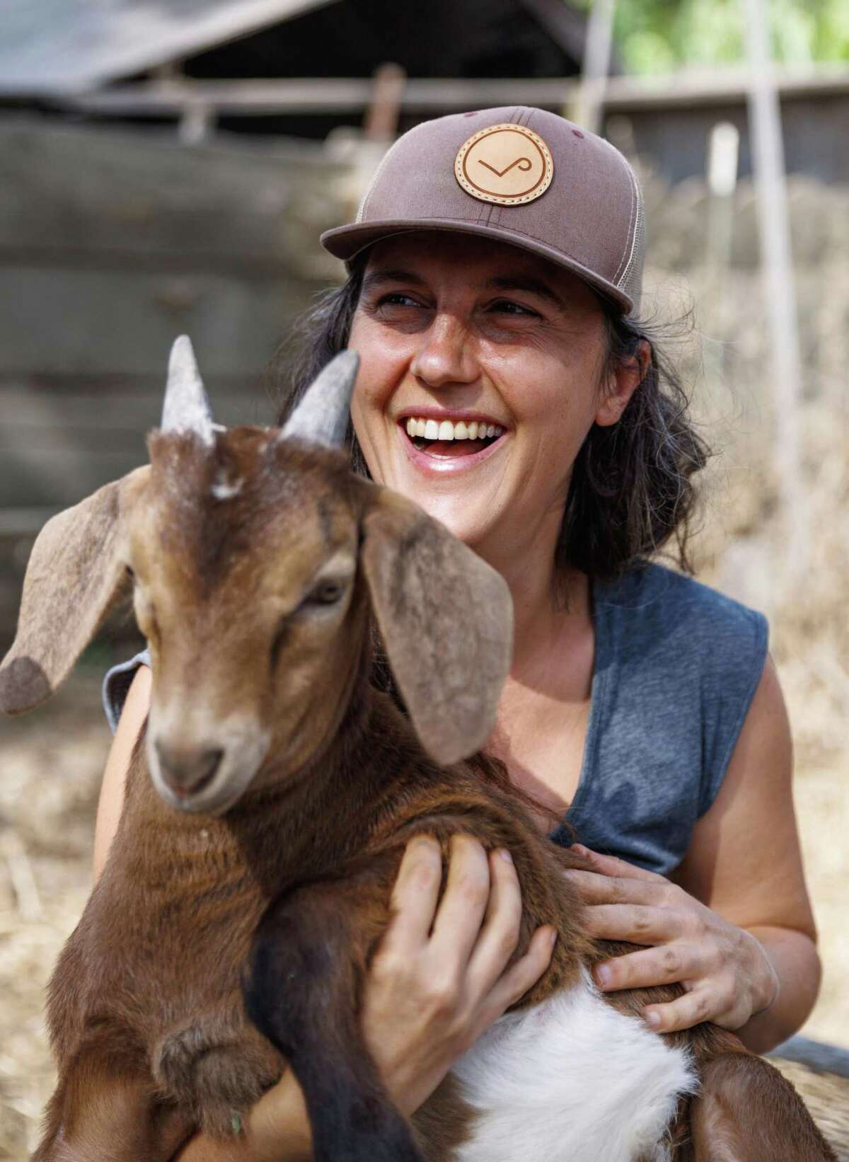 Erin Axelrod holds a goat at the Wild & Radish Eco-Village in El Sobrante. Axelrod invests in the operation as part of its specialist pension fund.