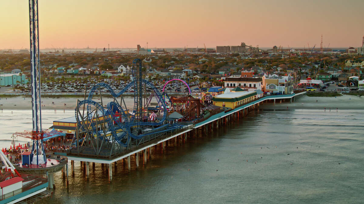 Aerial shot of the historic pier and the beach in Galveston, Texas at sunset. 