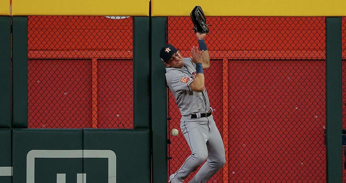 Mauricio Dubon #14 of the Houston Astros collides with the outfield fence as he fails to catch this two-run double by Dansby Swanson #7 of the Atlanta Braves in the sixth inning at Truist Park on August 19, 2022 in Atlanta, Georgia. (Photo by Kevin C. Cox/Getty Images)