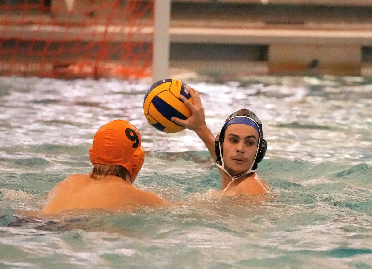 Austin's Joaquin Rosales looks to pass the ball against Elkins' William Remmert (9) during the second half of a boys high school water polo match between Fort Bend Austin and Fort Bend Elkins at Don Cook Natatorium on Friday, Aug. 19, 2022 in Sugar Land. Elkins won 14-7.