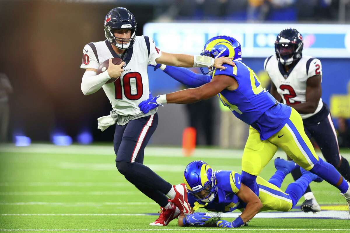 INGLEWOOD, CALIFORNIA - AUGUST 19: Davis Mills #10 of the Houston Texans runs from a defender in the first quarter during a preseason game against the Los Angeles Rams at SoFi Stadium on August 19, 2022 in Inglewood, California.