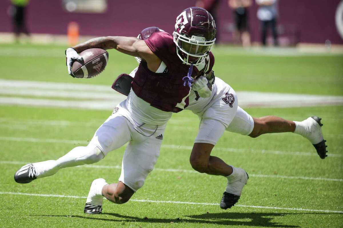 Texas A&M wide receiver Evan Stewart (1) fifths for extra yardage after making a catch against defensive back Josh Moten during the first half of the annual Maroon and White football game at Kyle Field Saturday, April 9, 2022, in College Station.