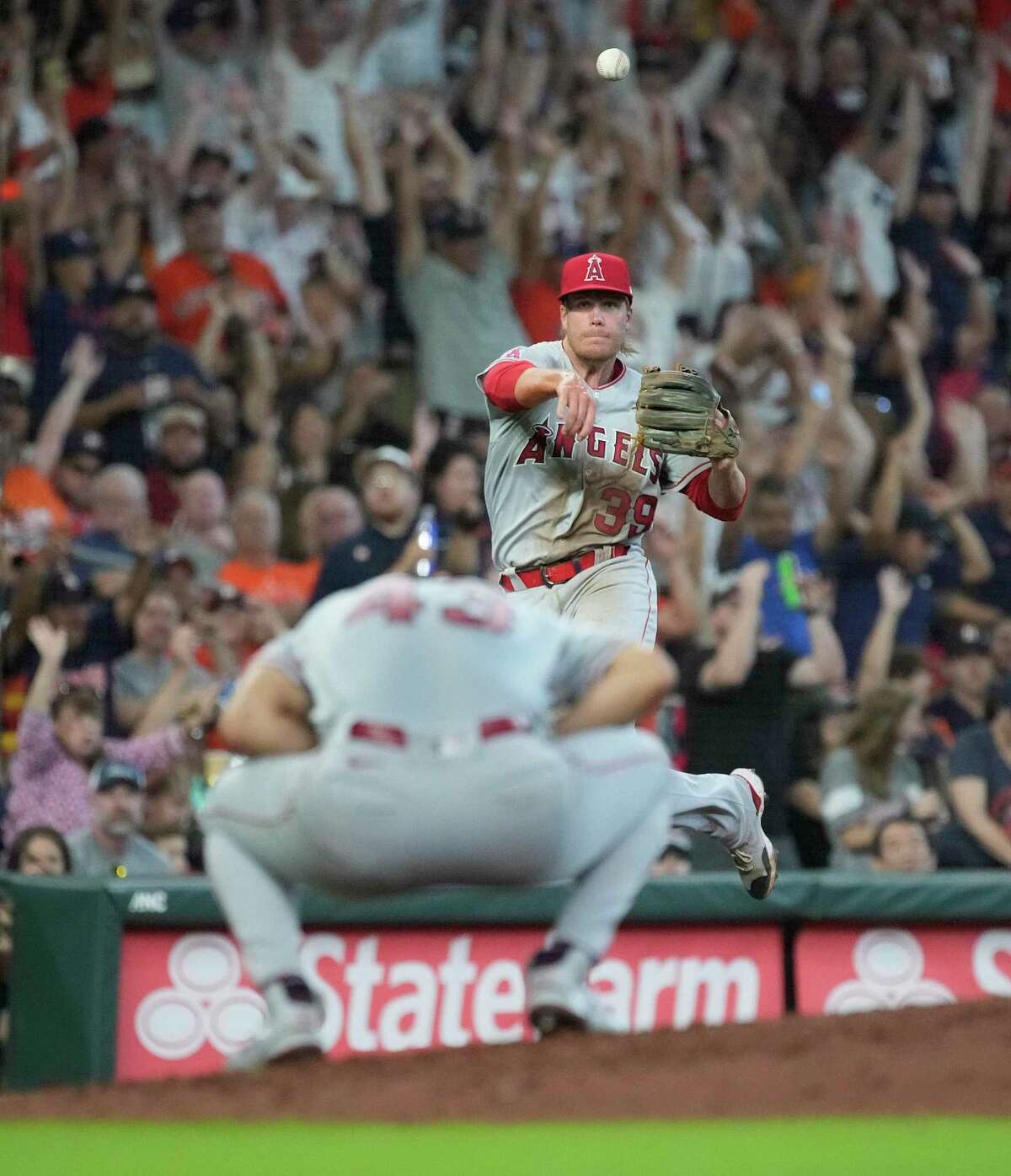 Los Angeles Angels third baseman David MacKinnon (39) tries to make the throw to first base over starting pitcher Patrick Sandoval as Houston Astros Jeremy Peña singled during the fourth inning of an MLB game at Minute Maid Park on Saturday, July 2, 2022 in Houston.