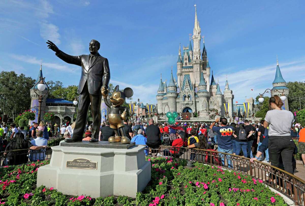 A statue of Walt Disney and Mickey Mouse in front of the Cinderella Castle at the Magic Kingdom at Walt Disney World in Orlando, Fla.