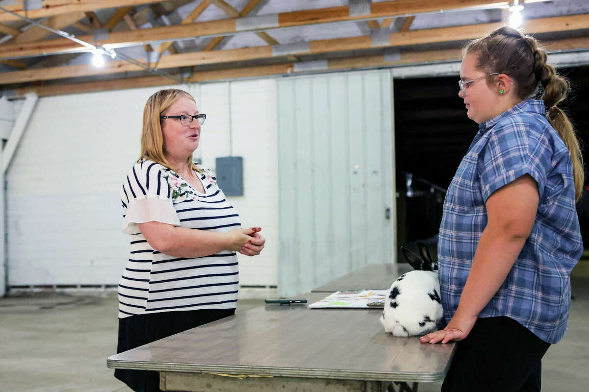 Allison Olson(left) listens as Amelia Sexton gives a presentation about her companion animal, a bunny rabbit named Black Beans and White Race on Saturday at the Manistee County Fairgrounds in Onekama. 