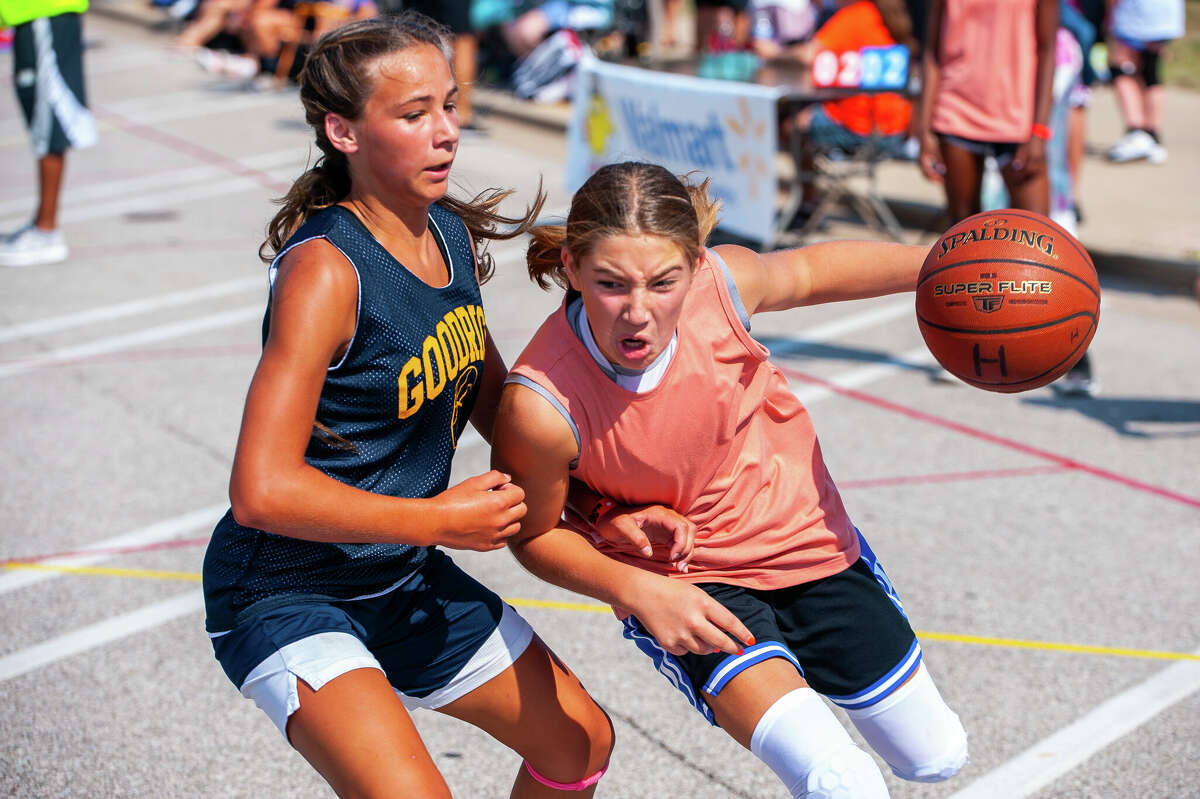 Romeo resident Madison Repicky, 12 (right), handles the ball as Goodrich resident Baylor Lauinger, 12, defends her at the Midland Gus Macker Tournament on Saturday in Downtown Midland.