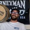 Grant Greiffendorf of Journeyman Distillery holds up a beer barrel in front of their flag at the Great Lakes Beer Fest, Saturday, Aug. 20, 2022 at Dow Diamond.