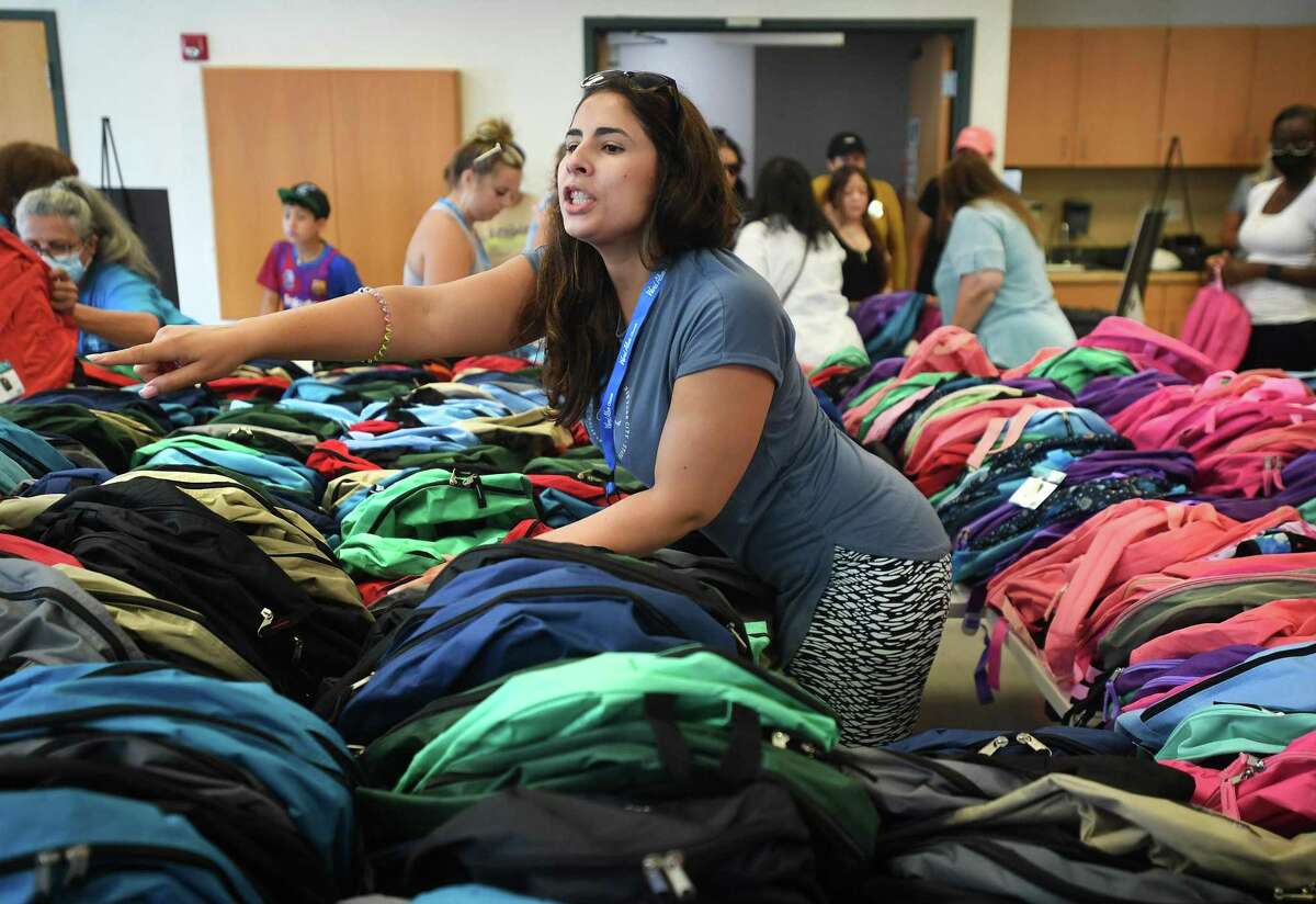Volunteer Bruna Bellairs, of Norwalk, works amid a sea of over one thousand new backpacks during Word Alive Church's annual schiool supply distribution at the Norwalk Police Department in Norwalk, Conn. on Saturday, August 20, 2022.