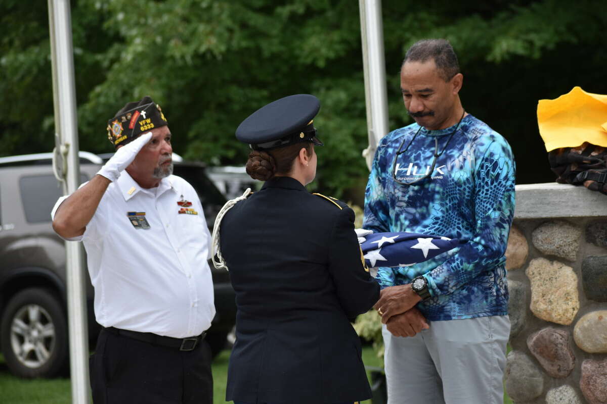 Norman’s nephew, retired Michigan State Police Detective Lt. Harry Norman accepts a flag presented by an honor guard from the Mecosta County Veterans of Foreign Wars.