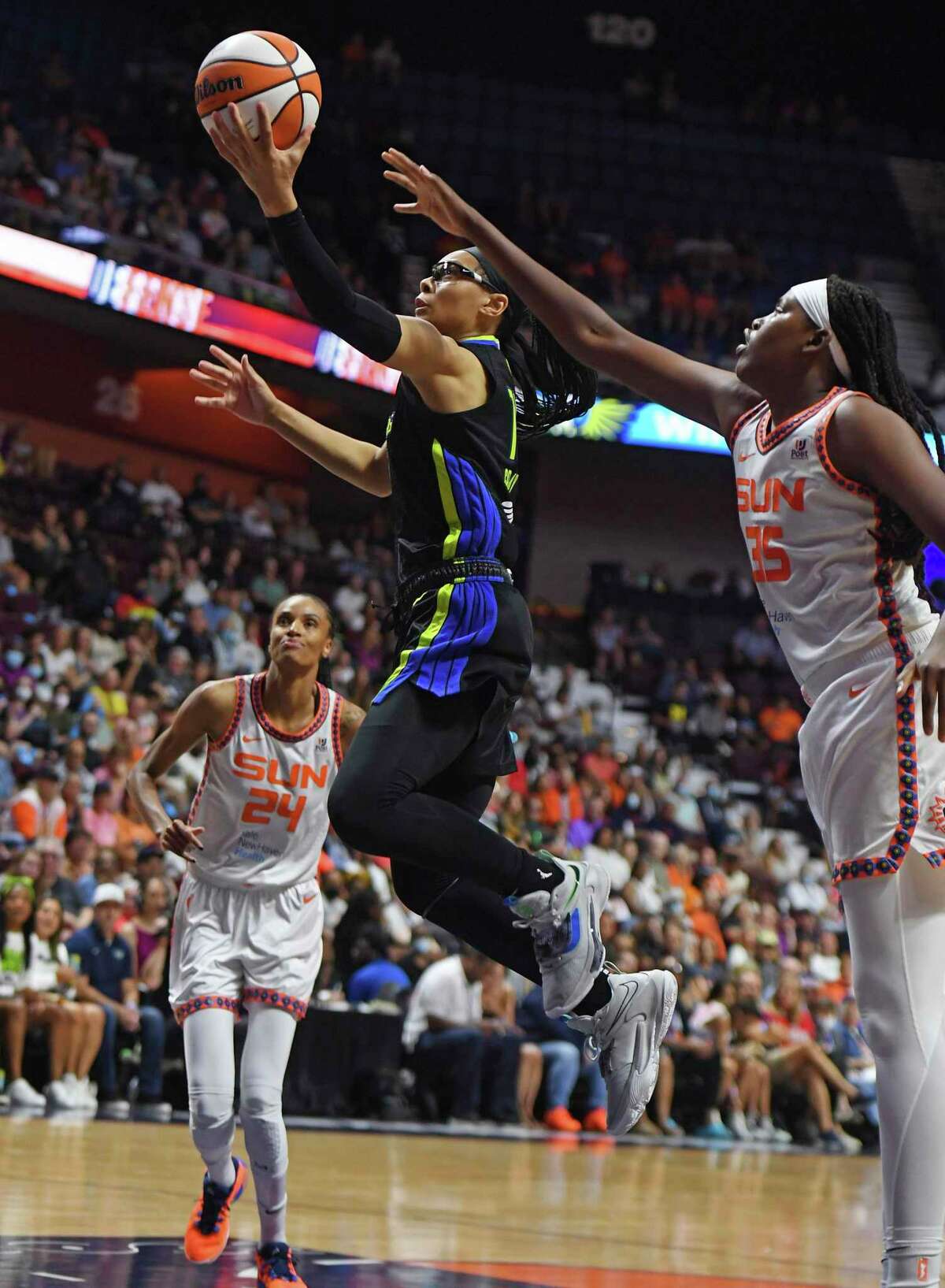 Dallas Wings guard Allisha Gray, center, drives between Connecticut Sunn defenders Jonquel Jones (35) and DeWanna Bonner (24) during Game 2 of a WNBA basketball first-round playoff series Sunday, Aug. 21, 2022, in Uncasville, Conn. (Sean D. Elliot/The Day via AP)