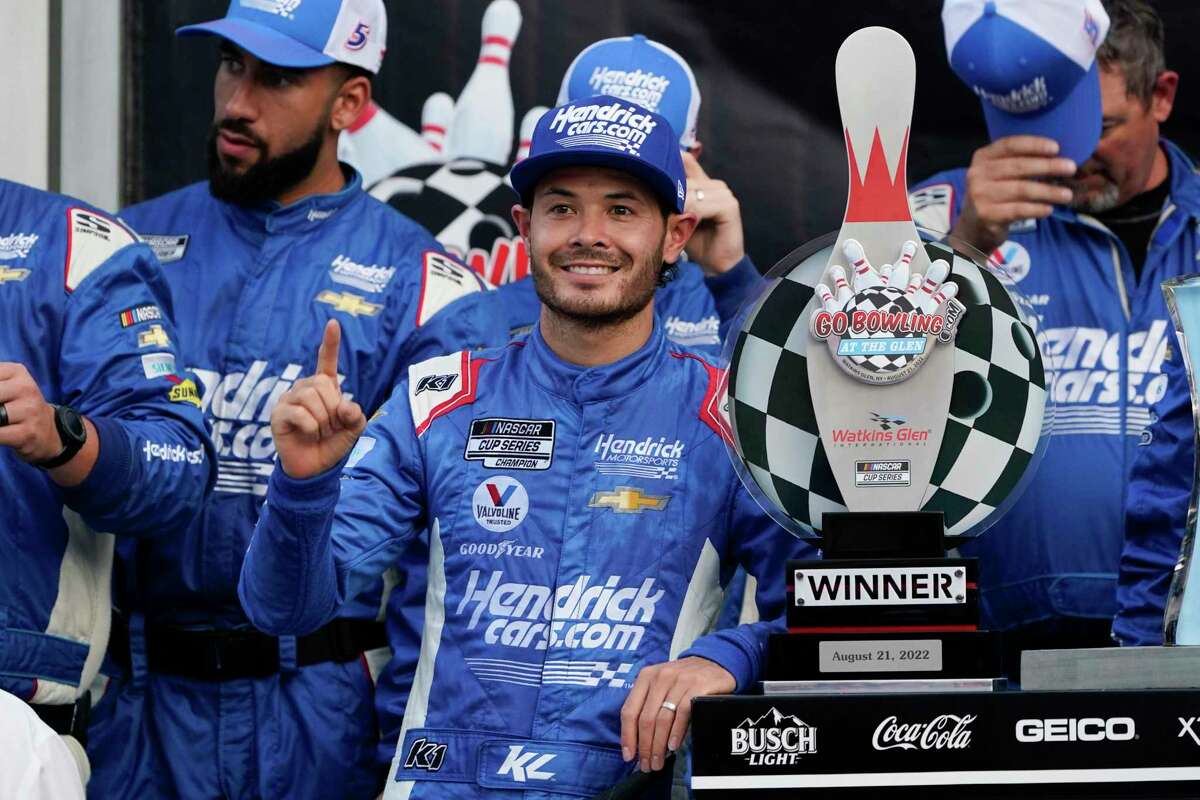Kyle Larson poses for photos with the trophy and his team after winning a NASCAR Cup Series auto race in Watkins Glen, N.Y., Sunday, Aug. 21, 2022. (AP Photo/Seth Wenig)