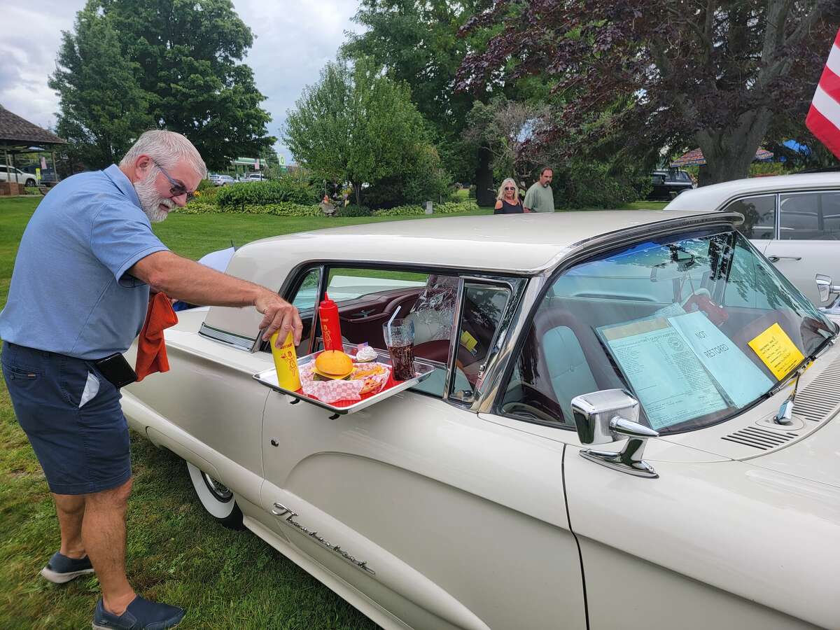 An exhibitor at the Collector Car Show adjust the prop food on his entry. 