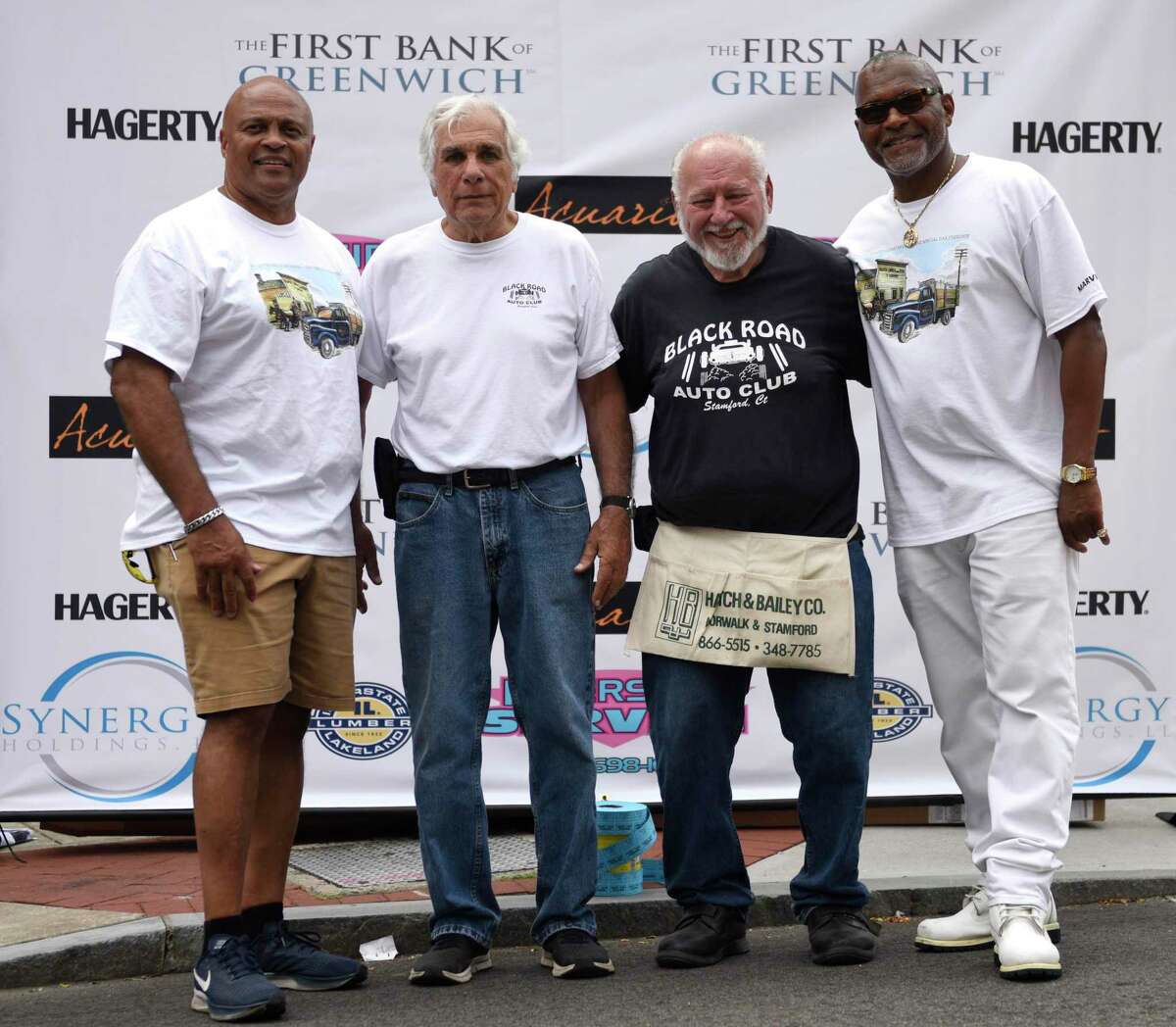 Event organizers, from left, Guy Fortt, Butch Macchio, Gene Rizzo and Russell Davis pose at the Cruising Stamford auto show at Columbus Park in Stamford, Conn.  Sunday, August 21, 2022. More than 150 vintage to early 80's cars are on display on Main Street, with live music, outdoor dining, face painting, prizes and more.  The event, now in its second year, was presented by First Bank of Greenwich, Synergy1Holdings and BlackRoads Auto Club to honor Eversource Energy and the US Postal Service.