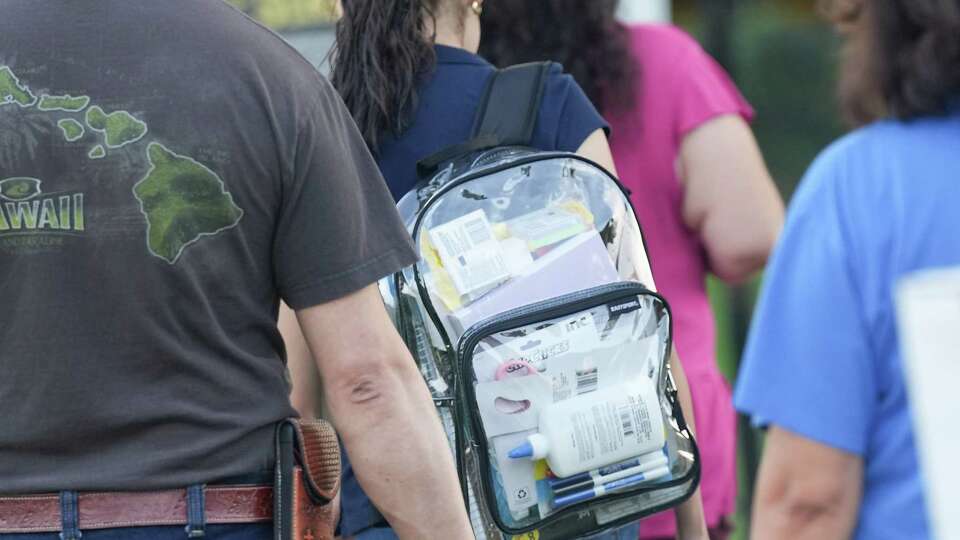 A student at Marshall Middle School walks into the school courtyard with a clear backpack on Sunday, Aug. 21, 2022 in Houston.