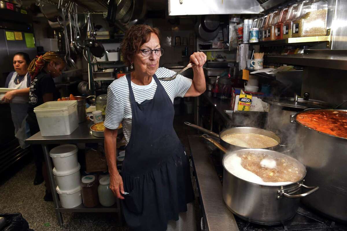 Owner Claire Criscuolo tastes ginger syrup on the stove in the kitchen of Claire's Corner Copia in New Haven on August 22, 2022.