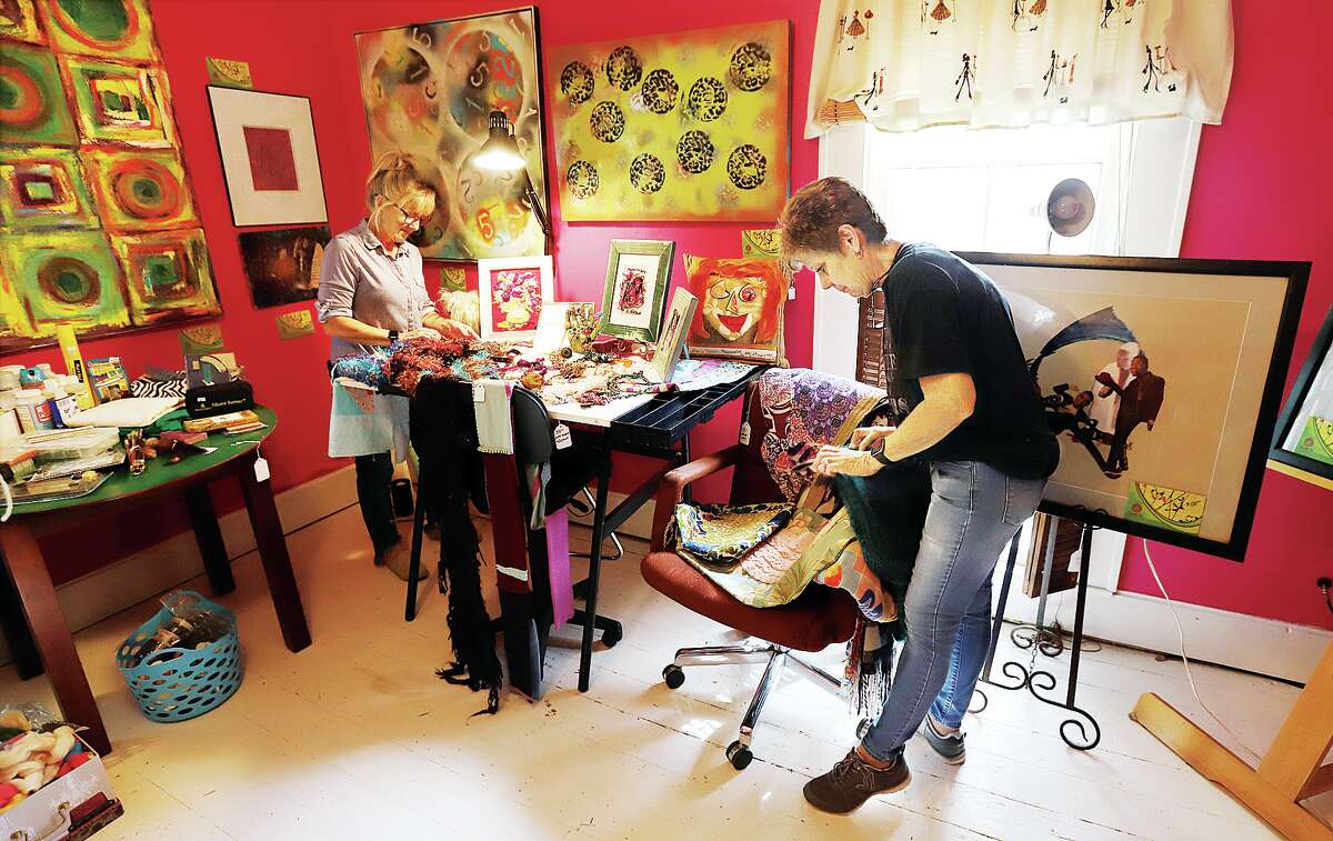 John Badman|The Telegraph Tina Mundt, left, and Paula Butler, right, owners of Red Barn Estate Sales, prepare items in the home of the late Mary Lu McManus. The former South Roxana teacher had plenty of art items she had made over the years which will be sold Wednesday 8 a.m. to 5 p.m. The two-day estate sale will continue Thursday from 8 a.m. to noon, but her artwork will only be available Wednesday.