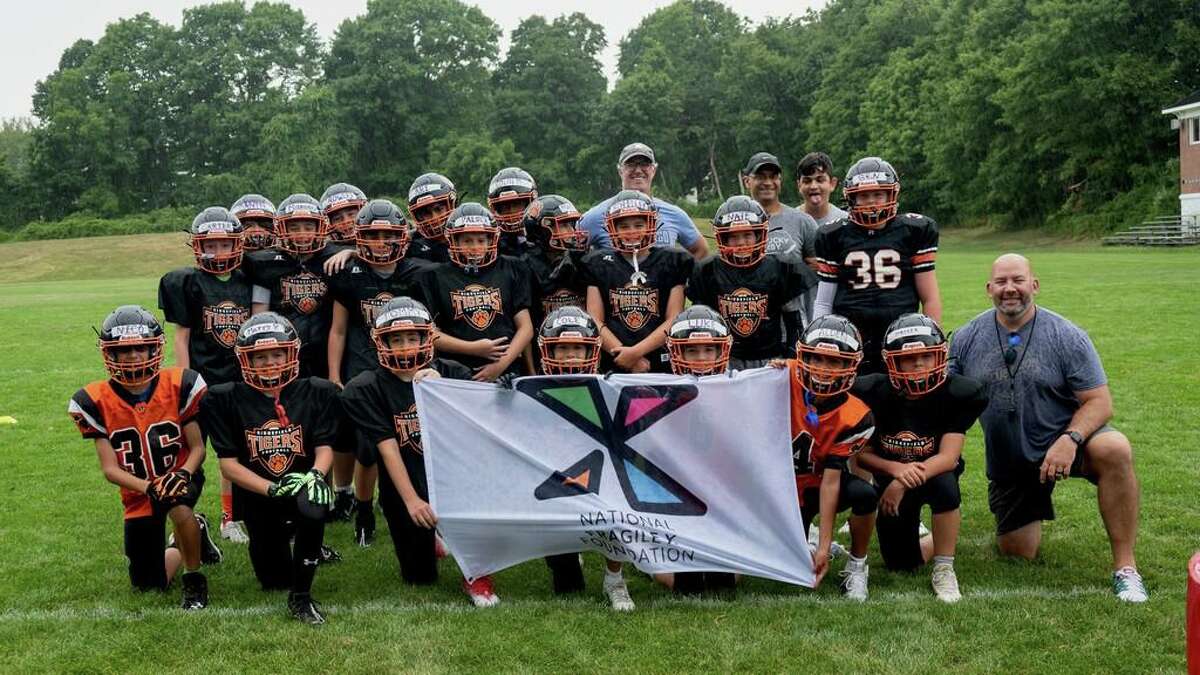 Starting Aug. 15, the Ridgefield Youth Football team welcomed Ridgefield ninth grader Jordan Sarup (in back on right) onto the team. Jordan was asked by the team's coaches to help referee and coach the team during its practices this fall.