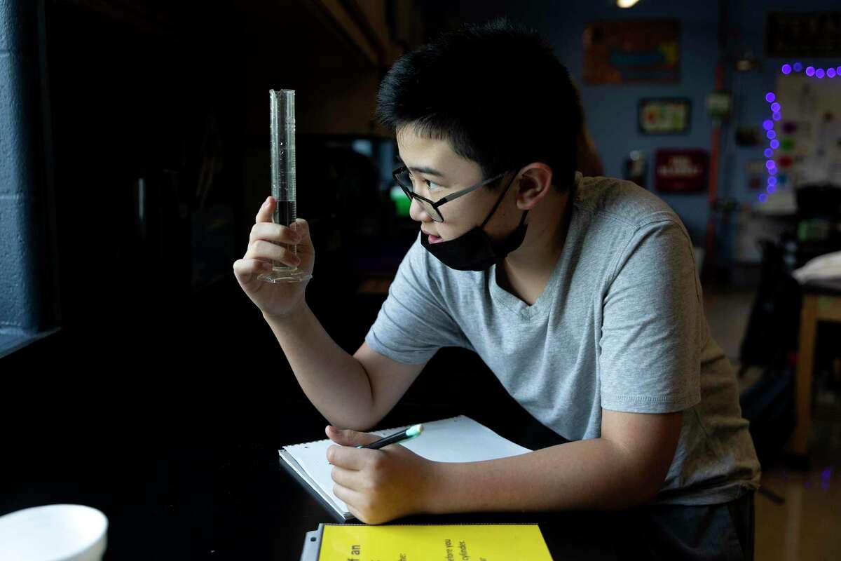 Ethan Doan measures the volume of a plug in Shauna Garner's 8th grade science class at Tex Hill Middle School. Garner (not pictured), at the Texas Institute of Biomedical Sciences, is helping create new programs to connect local middle and high school science teachers with researchers and use their research as a teaching tool.