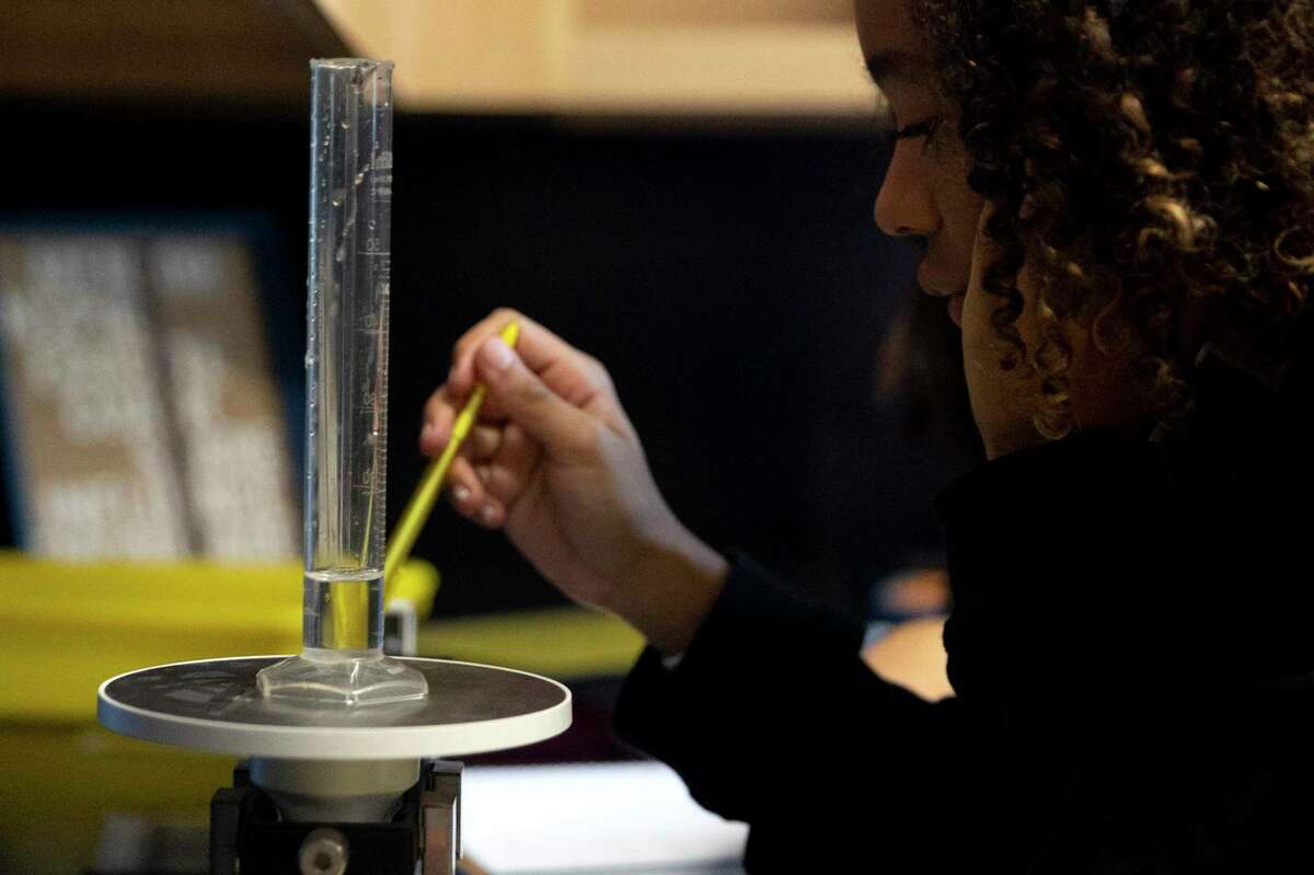 Mia Gottlieb measures the mass of 10 milliliters of water using a scale in Shaunna Garner’s eighth grade science class at Tex Hill Middle School. Garner (not pictured) is helping create a new program at Texas Biomedical Research Institute to connect local middle school and high school science teachers with researchers, and to use their work as a teaching tool.