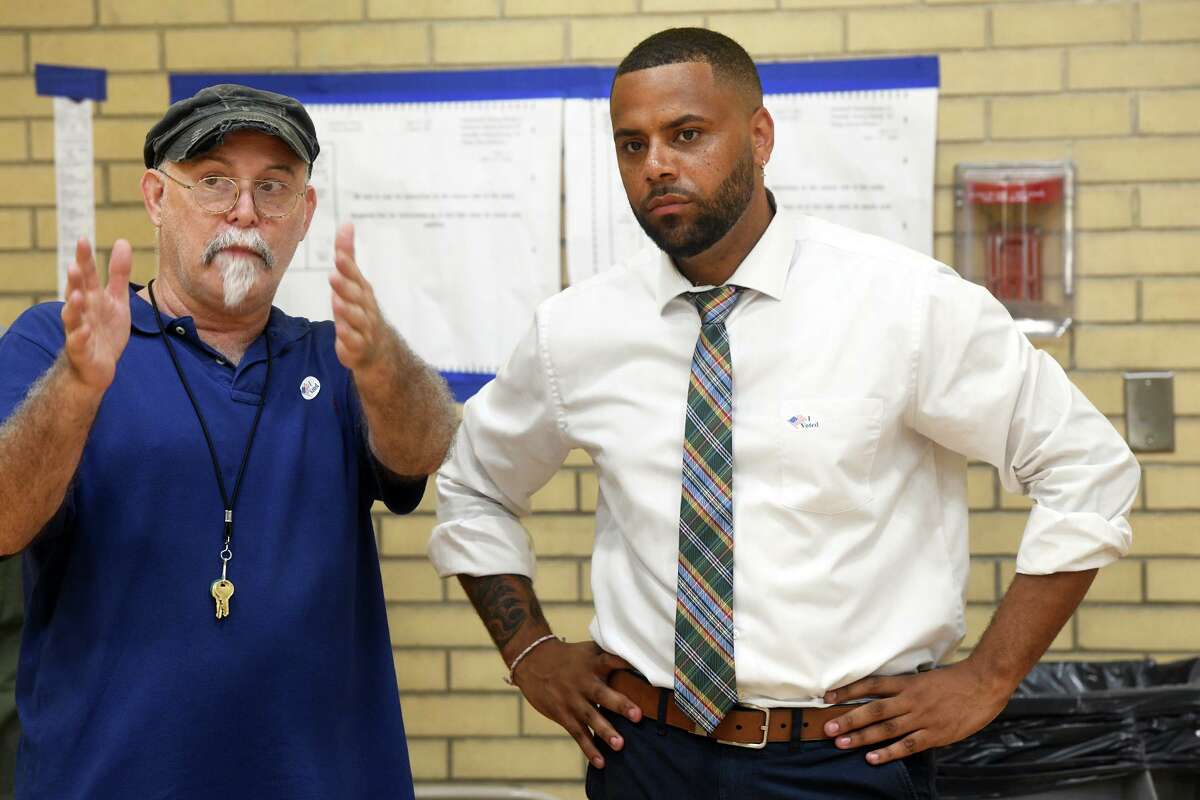 City Councilman Marcus Brown speaks with election moderator Chuck Hebert after Brown voted at Blackham School in Bridgeport, Conn. Aug. 9, 2022. Brown challenged incumbent State Rep. Jack Hennessy in Tuesday’s Democratic primary for 127th house seat.