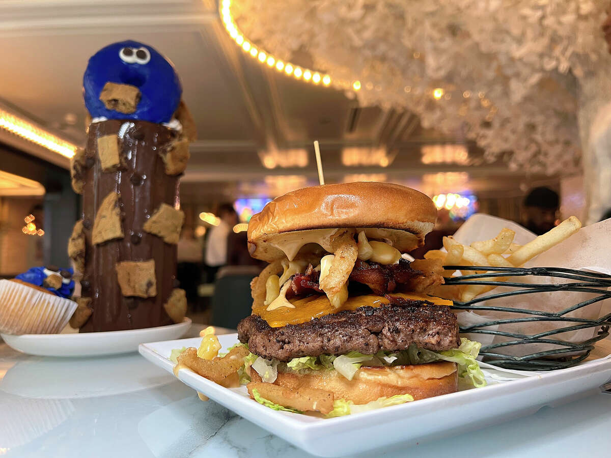 The Big Cheesy burger includes macaroni and cheese and bacon, while the Cookie Monster shake includes a blue frosted doughnut, a cupcake, chocolate chip cookies and a chocolate-coated glass filled with a cookies-and-cream milkshake at Sugar Factory American Brasserie at The Shops at Rivercenter on the San Antonio River Walk. 