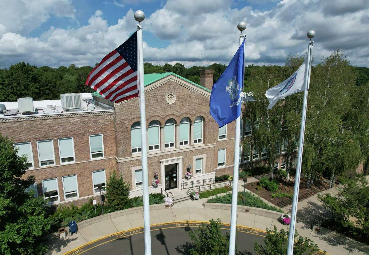 Flags fly outside of Town Hall in Darien, Conn. Tuesday, Aug. 23, 2022.