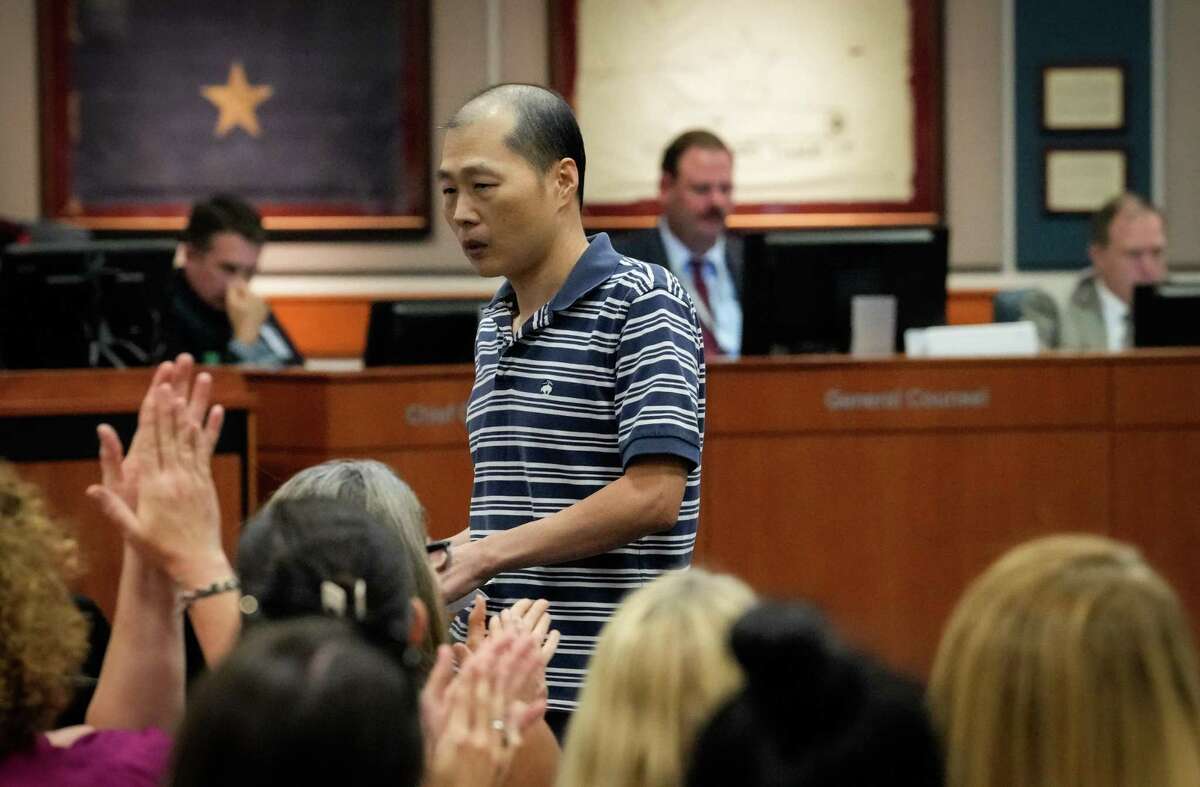A man receives applause after he spoke in favor of removing books from school libraries over alleged vulgarities during a school board meeting Monday, Aug. 22, 2022, at Katy ISD Educational Support Complex in Katy.