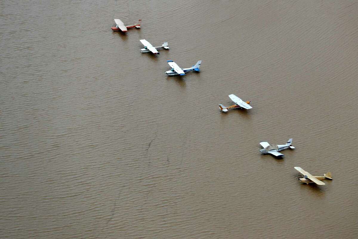 A line of airplanes is surrounded by floodwaters from Tropical Storm Harvey on Tuesday, Aug. 29, 2017, in Houston. 