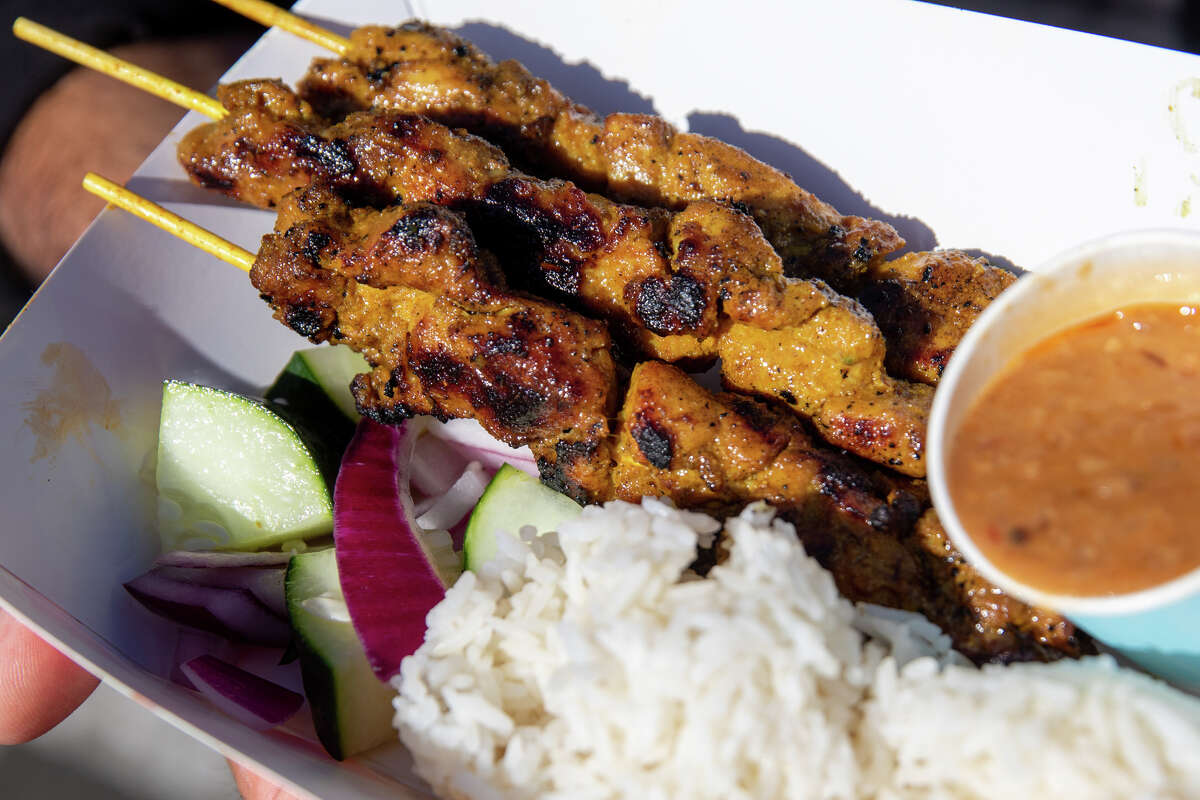 Satay by the Bay's chicken satay, served with rice, cucumber, and their homemade peanut sauce at Off The Grid at Fort Mason in San Francisco, Calif. on Aug. 19, 2022. The food truck, run by couple Elly and David Greenfield, is SF's only Singaporean Halal food truck.