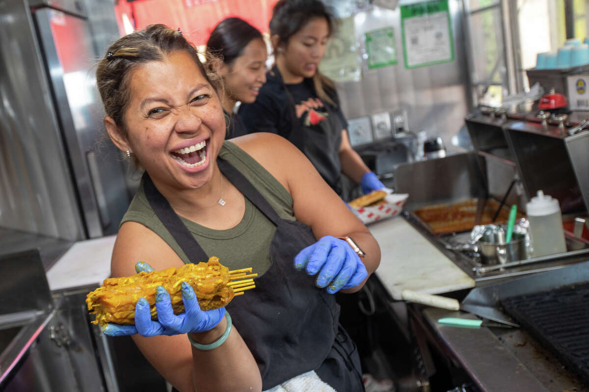 Satay by the Bay co-owner Elly Greenfield prepares to grill some chicken satay in her food truck at Off The Grid at Fort Mason in San Francisco, Calif. on Aug. 19, 2022.
