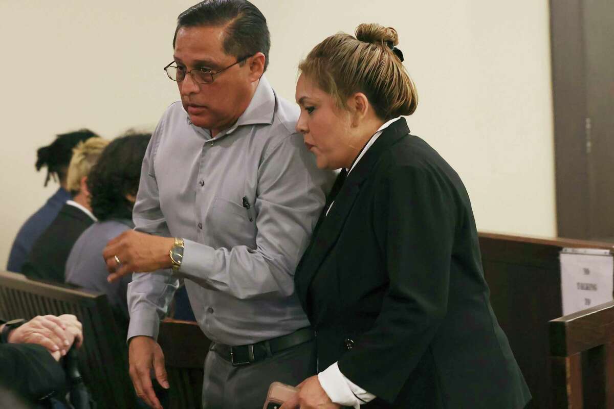 Former constable Michelle Barrientes Vela walks out of the courtroom with her husband, Carlos, on the first day of her felony tampering with evidence trial in the 226th District Court on Tuesday.
