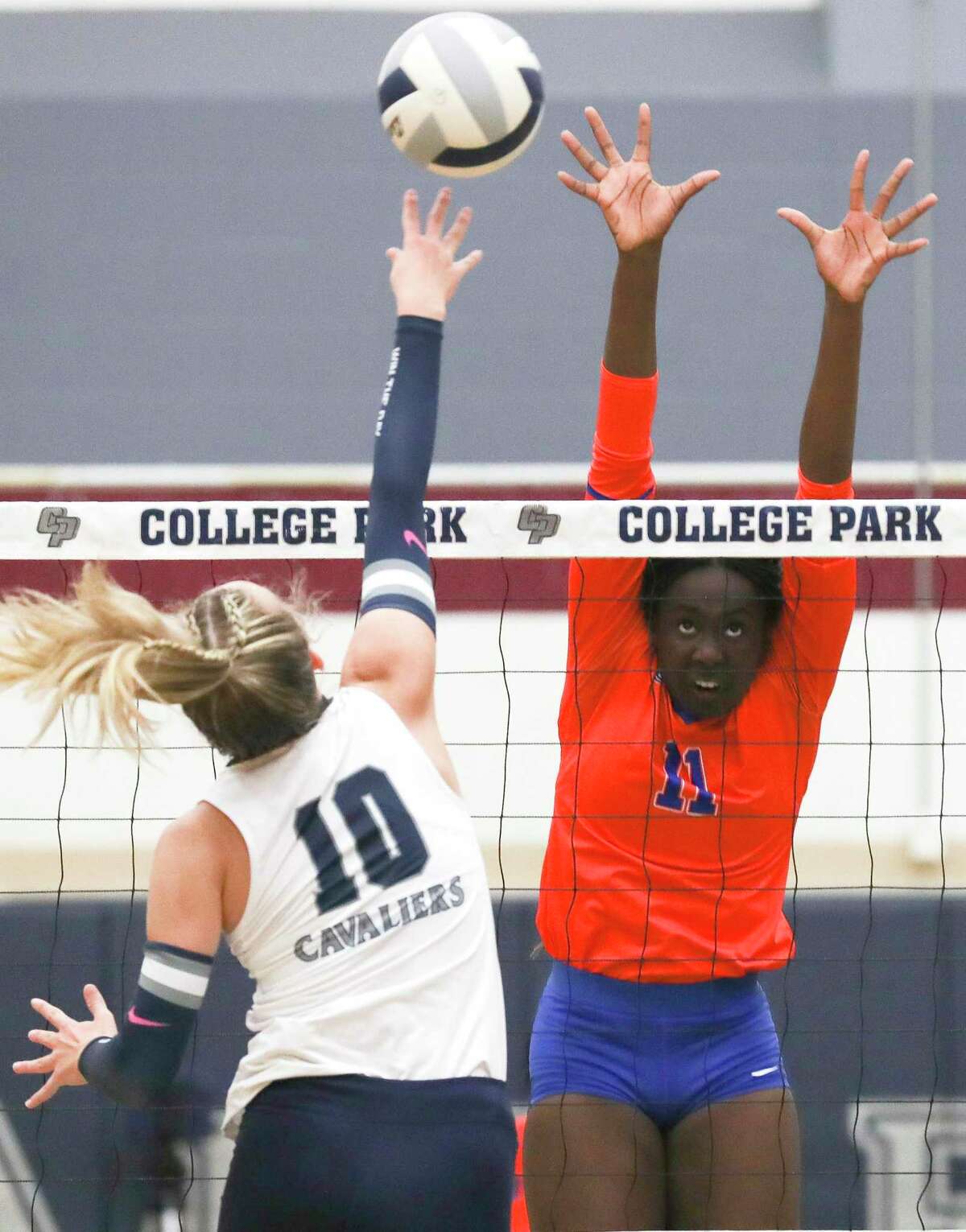 Grand Oaks' Jaela Auguste (11) pressures a shot by College Park's Cassidy Copeland (10) in the first set of a District 13-6A high school volleyball match at College Park High School, Tuesday, Aug. 23, 2022, in The Woodlands.