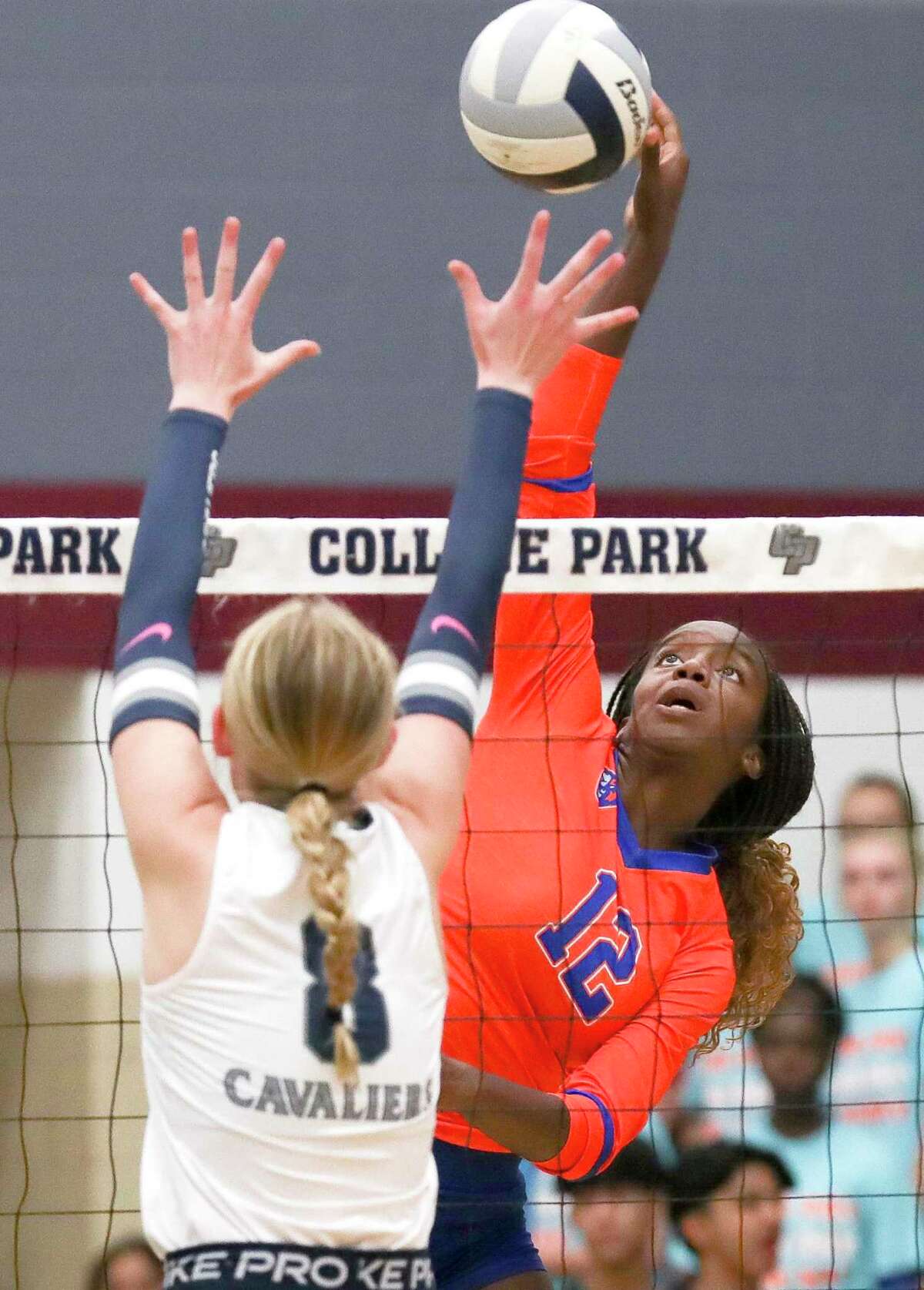 Grand Oaks' Samara Coleman (12) gets a shot past College Park's Cassidy Copeland (10) and Reese Ellen (8) in the first set of a District 13-6A high school volleyball match at College Park High School, Tuesday, Aug. 23, 2022, in The Woodlands.