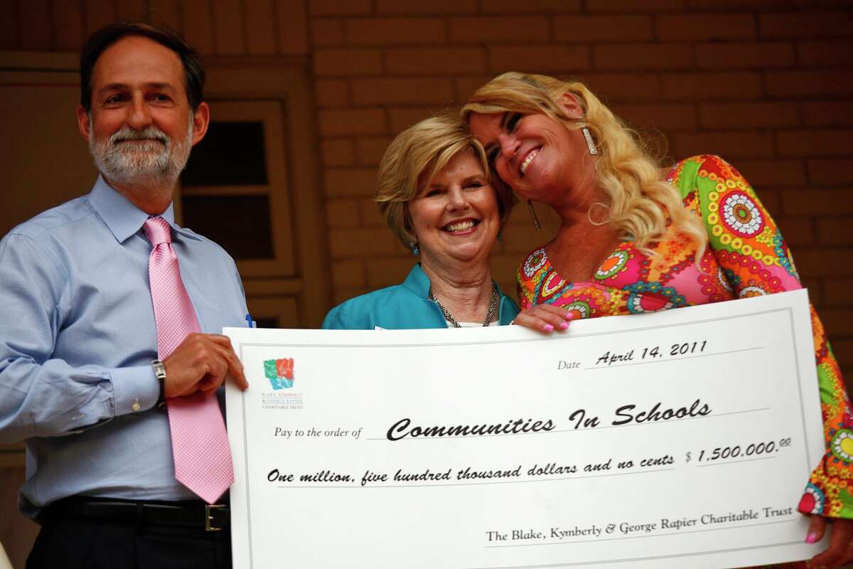 Kym Rapier, right, with her then-husband, Dr. George Rapier III, present a donation to Communities in Schools in San Antonio in 2011. The majority of donations he made to the Latino Coalition Foundation and the Hispanic Business Roundtable Institute did not go for their intended purposes.