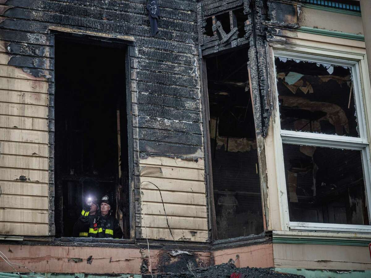 Firefighters observe the aftermath of a structure fire on McAllister Street in San Francisco, Calif., on Tuesday, Aug. 23, 2022. The three-alarm fire injured one woman.