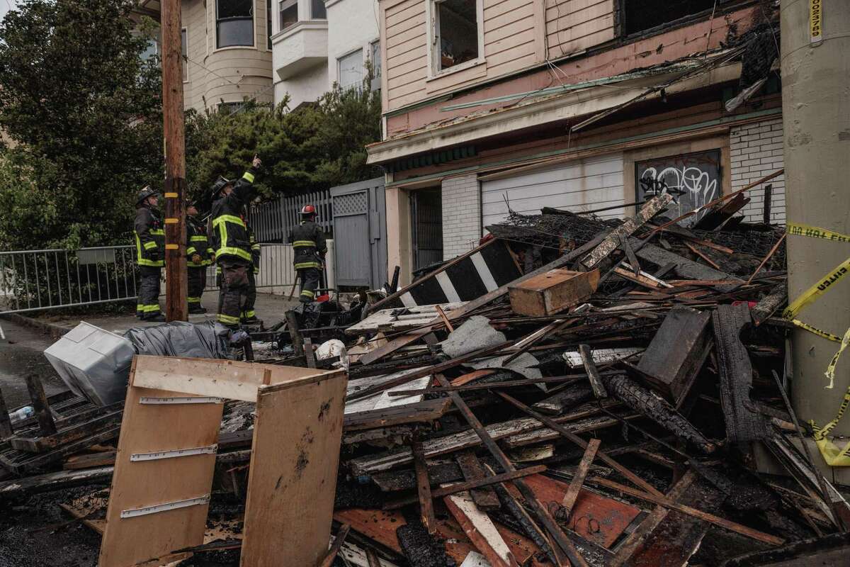 Firefighters observe the aftermath of a structure fire on McAllister Street in San Francisco, Calif., on Tuesday, Aug. 23, 2022. The three-alarm fire injured one woman.